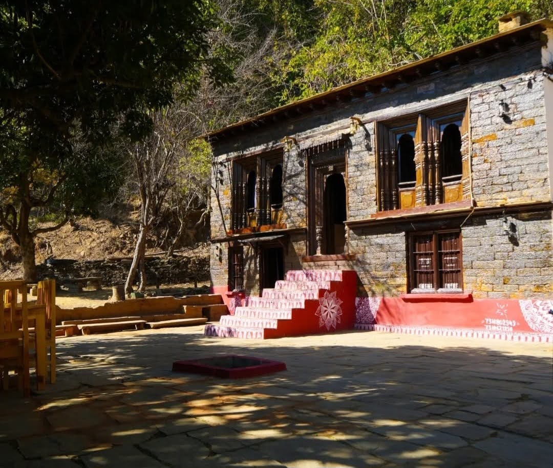 Exterior view of Daankudi Heritage Homestay with traditional wooden architecture and mountain backdrop