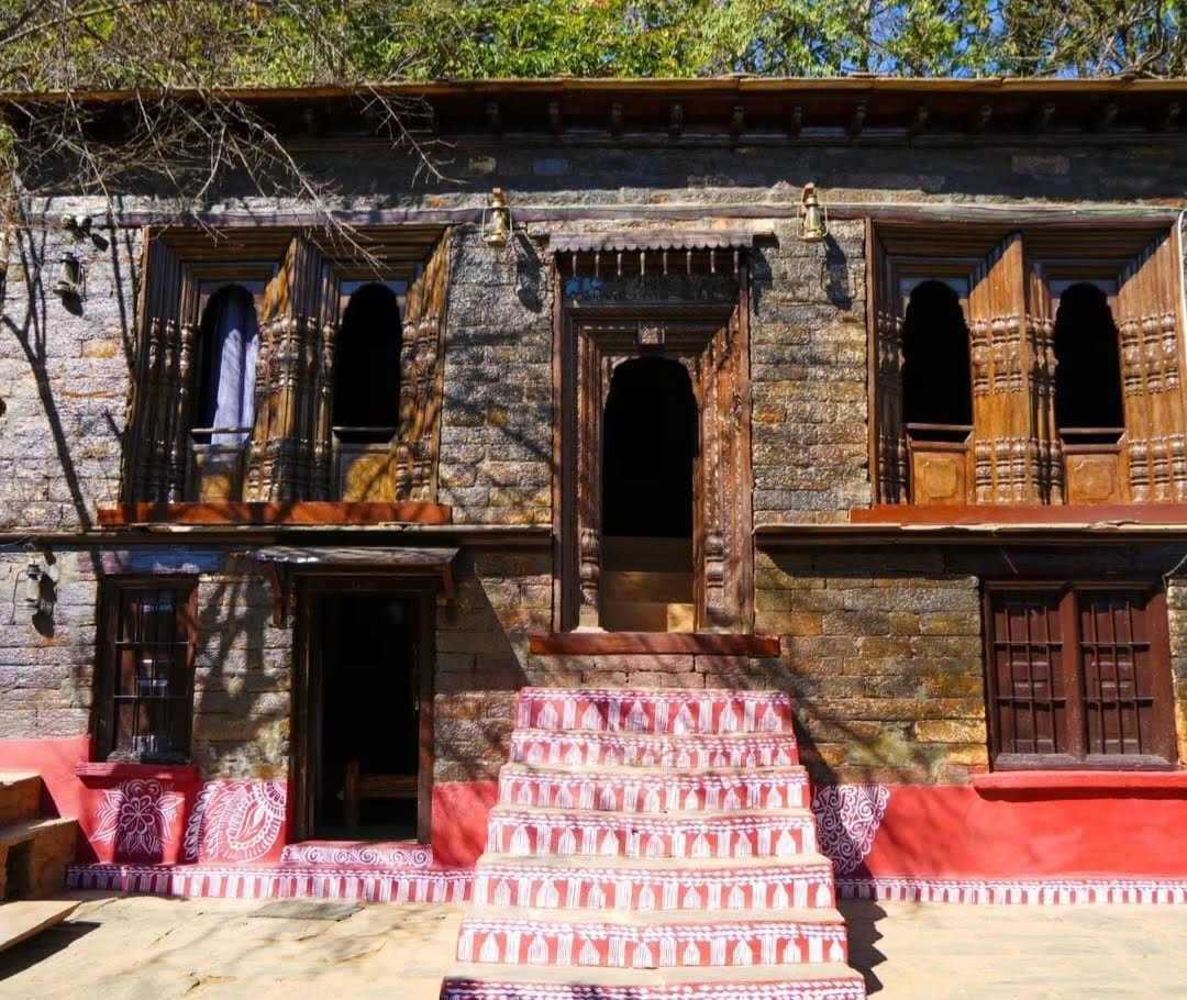 Front view of the Daankudi Heritage House with painted red steps and stone exterior