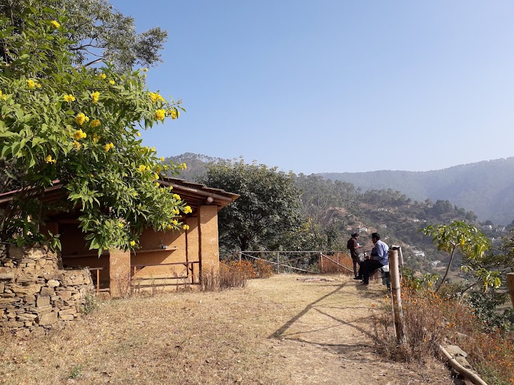 A small rustic cabin structure on a hillside overlooking the valley