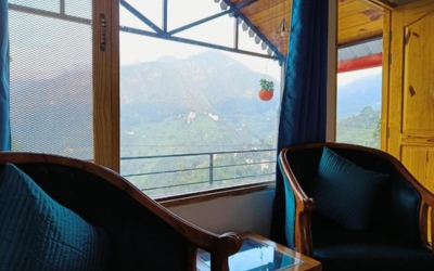 Two armchairs facing a large window with a spectacular mountain view