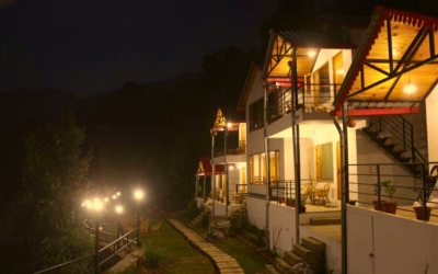 Cottages illuminated at night with string lights along the pathway
