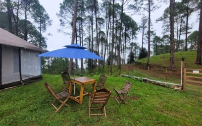 Outdoor seating area outside tents at Kausani Jungle Camp